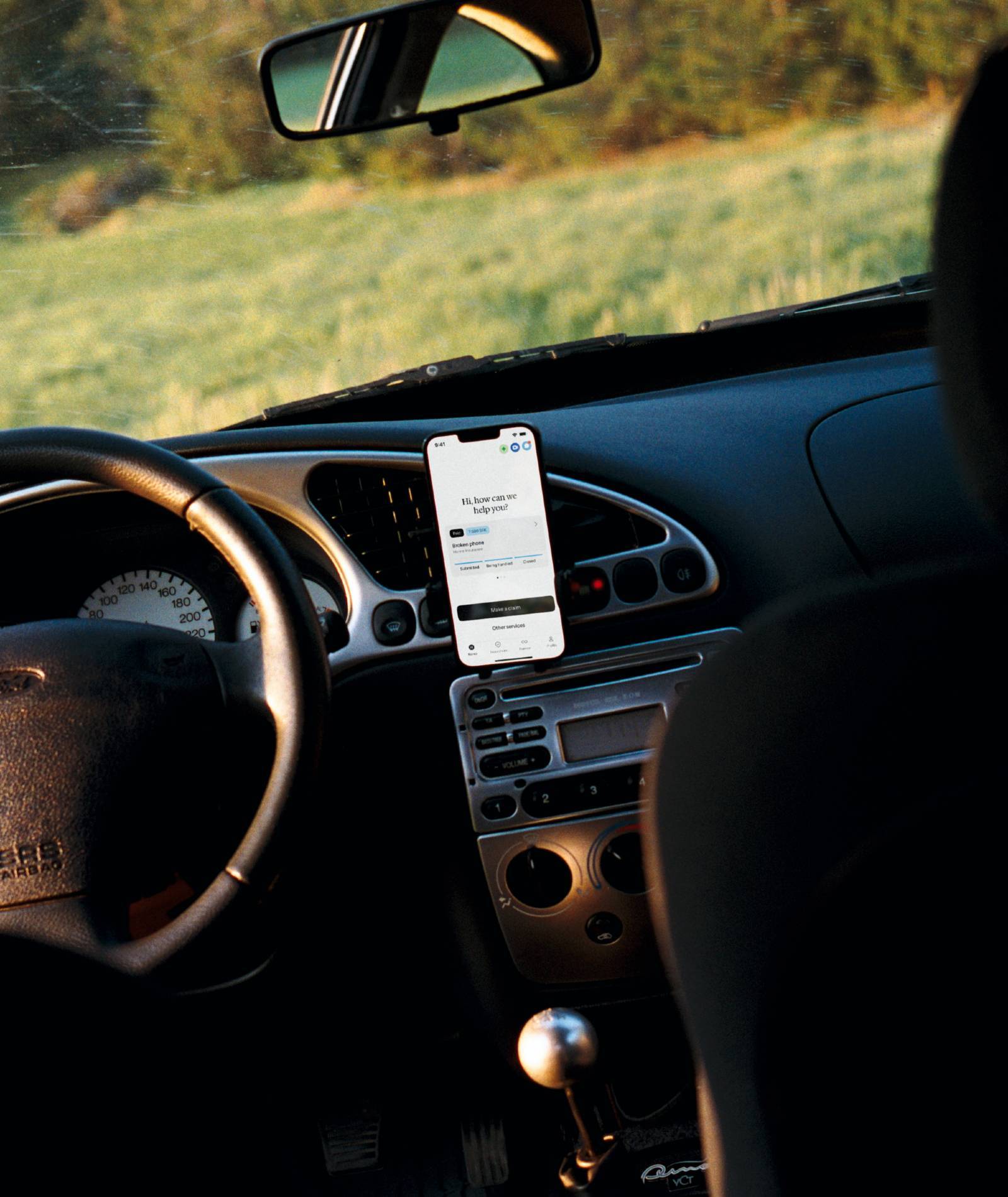 Mobile holder next to the steering wheel in a car.